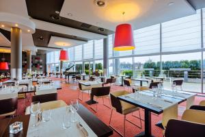restauracja ze stołami, krzesłami i oknami w obiekcie Qubus Hotel Kraków w Krakowie