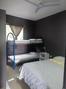 ein Schlafzimmer mit zwei Etagenbetten und einem Fenster in der Unterkunft Apartamento Familiar 3 con 3 habitaciones 4 camas más litera in San Salvador