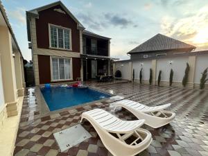 a house with a swimming pool and two lounge chairs at Mountain Villa in Gabala