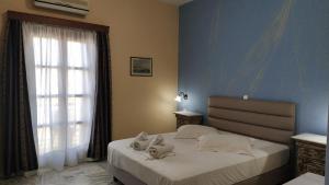 a bedroom with a bed with two stuffed animals on it at Vaporia in Ermoupoli