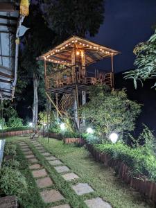 a tree house in the middle of a garden at night at CharDara Agrotourism & FarmStay in Mahabaleshwar