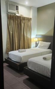 Postel nebo postele na pokoji v ubytování Lorenzzo Suites Hotel Makati