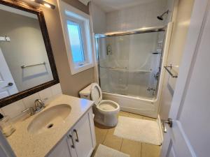 a bathroom with a shower and a toilet and a sink at Burnaby 4 bed 3 bath duplex in Burnaby