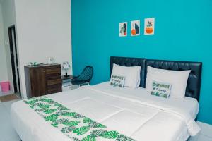 a bedroom with a large bed with a blue wall at RedDoorz at Tienery Guest House in Tanjungkarang +10 photos