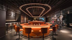 un bar con sedie arancioni e tavolo rotondo di CapsuleTransit MAX - Airport Hotel - Landside, Public Area - Gateway KLIA T2, Lvl 2M a Sepang