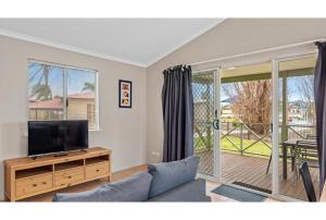 a living room with a couch and a flat screen tv at Discovery Parks - Bunbury Foreshore in Bunbury