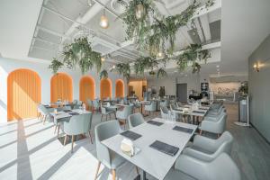 a restaurant with tables and chairs and plants at Act Hotel in Daegu