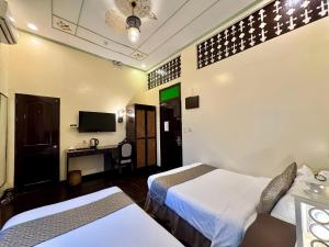 a hotel room with two beds and a television at Park Avenue Boutique Hotel Manila in Manila