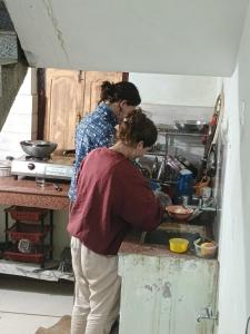 two women standing in a kitchen preparing food at Budha ashram guest house in Bodh Gaya