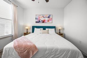 a bedroom with a large white bed with a blue headboard at Charming Frisco Apt with Pool & Gym in Frisco