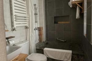 楽山市にあるMount Emei Bamboo Private Hot Spring Bed and Breakfastのトイレ、浴槽、洗面台を備えたバスルーム