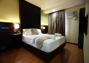 Postel nebo postele na pokoji v ubytování Lorenzzo Suites Hotel Makati