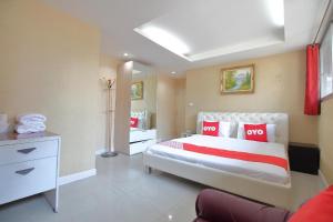 a bedroom with a large bed with red pillows at Diamond Residence Silom in Bangkok