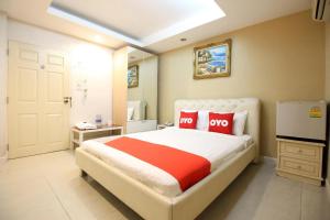a bedroom with a large bed with red pillows at Diamond Residence Silom in Bangkok