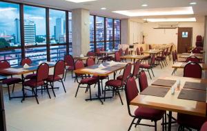 a dining room with tables and chairs and windows at Lis Hotel in Teresina