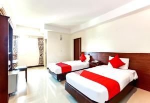 a hotel room with two beds and a television at Collection O VResotel in Nonthaburi