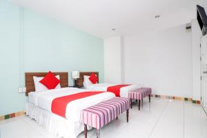 two beds with red and white sheets in a room at King One Suvarnabhumi in Bangkok +32 photos