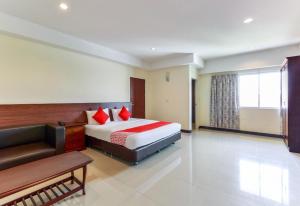 a hotel room with a bed and a couch at Collection O VResotel in Nonthaburi