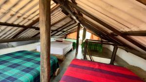a attic room with two beds and a rug at Xie-Hermosa cabaña con lago natural in Sáchica