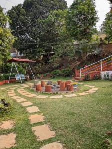 a garden with a stone path in the grass at CharDara Agrotourism & FarmStay in Mahabaleshwar