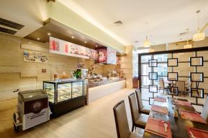 a restaurant with tables and chairs and a counter at Four Points by Sheraton Qingdao, Chengyang in Qingdao