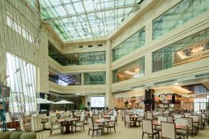 a restaurant with tables and chairs in a building at Four Points by Sheraton Qingdao, Chengyang in Qingdao