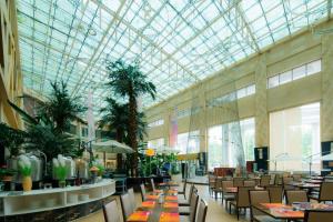a restaurant with tables and chairs and a glass ceiling at Four Points by Sheraton Qingdao, Chengyang in Qingdao