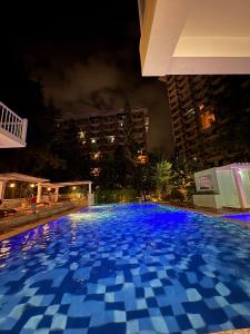 ein großer blauer Pool in der Nacht in der Unterkunft DandD's Place Studio Unit 1 with Free Netflix in Davao City