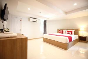 a bedroom with a large bed with red pillows at Super OYO 483 Pannee Hotel Khaosan in Bangkok