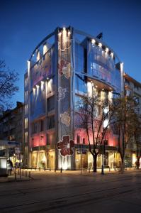 ein großes Glasgebäude mit seitlicher Beleuchtung in der Unterkunft Les Fleurs Boutique Hotel in Sofia