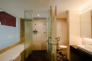 a bathroom with a shower and a toilet and a sink at Four Points by Sheraton Qingdao, Chengyang in Qingdao
