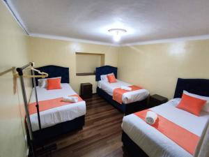 une chambre d'hôtel avec deux lits avec des oreillers bleus et orange dans l'établissement Qosqo Apartments 3, à Cusco