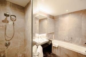 a bathroom with a shower and a sink and a tub at Four Points by Sheraton Qingdao, Chengyang in Qingdao
