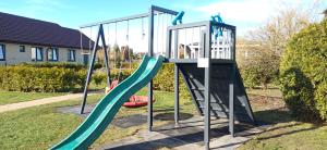 a playground with a slide in a yard at Family Garden House with Free Private Parking & Playground in Rīga