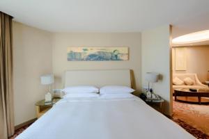 a bedroom with a large white bed and a couch at Four Points by Sheraton Qingdao, Chengyang in Qingdao