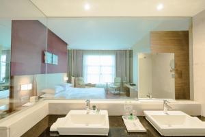 a bathroom with two sinks and a large mirror at Four Points by Sheraton Qingdao, Chengyang in Qingdao