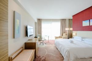 a hotel room with a bed and a desk at Four Points by Sheraton Qingdao, Chengyang in Qingdao +37 photos