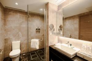 a bathroom with a toilet and a sink and a shower at Four Points by Sheraton Qingdao, Chengyang in Qingdao