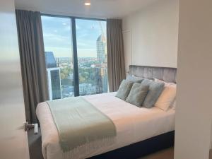 a bedroom with a bed with a large window at Gorgeous Seaview and Harbour View 2 BDR 2 BTH Apartment in Auckland