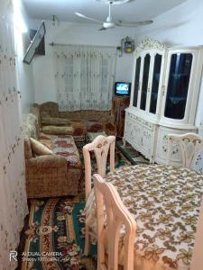 a living room with a couch and a table and chairs at شقة مفروشة للايجار فى دمياط القديمة الشارع الحربى in Dumyāţ