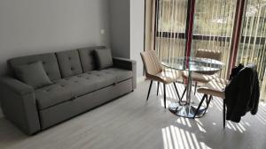 a living room with a couch and a table and chairs at Lugomar-Feijoo in Alpedrete