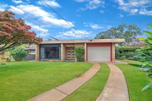 伊丘卡Jensen House - Retro Style with a modern update的砖房,有车库和草地庭院