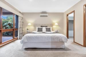 伊丘卡Jensen House - Retro Style with a modern update的卧室里有一张白色的大床和一扇窗户