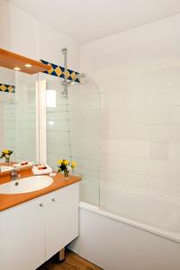 ein Bad mit einem Waschbecken und einer Dusche in der Unterkunft Séjours & Affaires Genève Saint Genis in Saint-Genis-Pouilly
