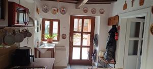 a kitchen with a door and plates on the wall at Vándor Kakas Vendégház dézsafürdővel in Recsk +37 photos