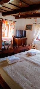 um quarto com duas camas e uma TV de tela plana em Vándor Kakas Vendégház dézsafürdővel em Recsk