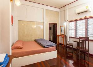 a room with a bed and a table and a desk at OYO 75469 Baan Kong Hostel in Ban Talat Takua Pa +17 photos