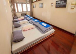 a group of beds lined up in a room at OYO 75469 Baan Kong Hostel in Ban Talat Takua Pa