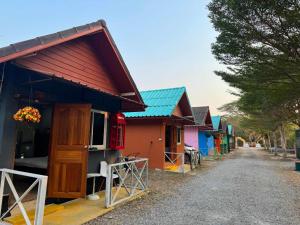 a row of colorful houses on a dirt road at OYO 75539 Phanthida Resort and Cafe in Hua Hin