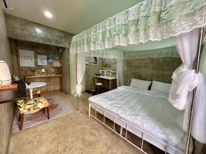 a bedroom with a canopy bed and a desk at OYO 75539 Phanthida Resort and Cafe in Hua Hin